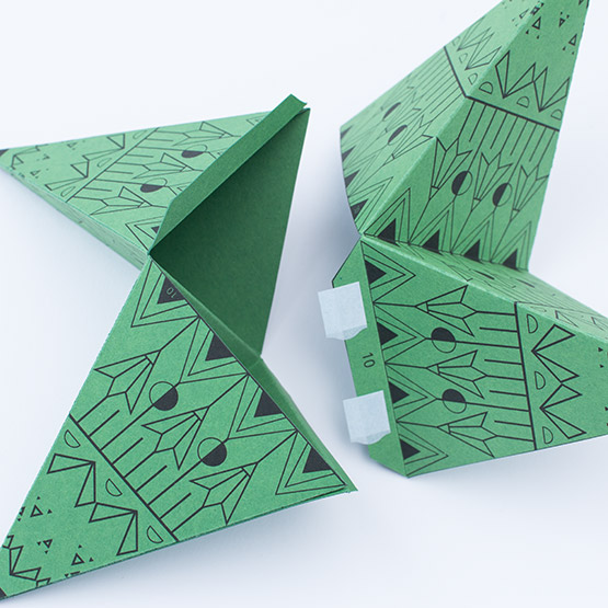Gluing numbered polygon pieces together on a green template to form the XXL Christmas star.