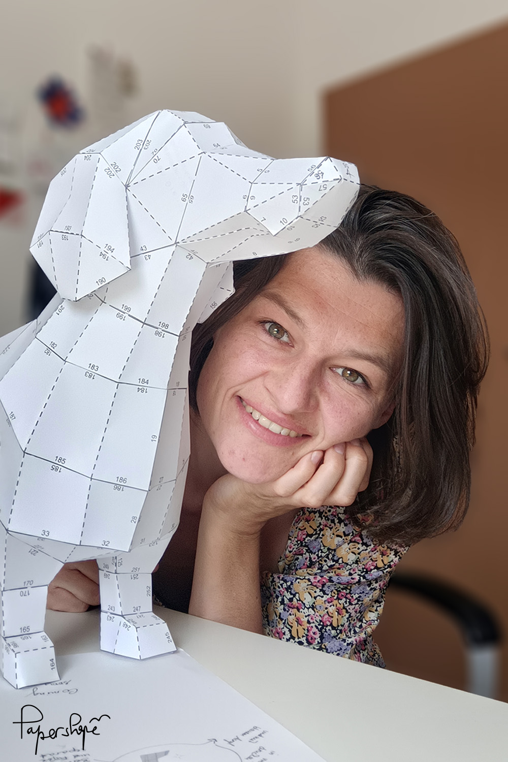 Papierkünstlerin mit einem selbstgebastelten 3D Papier Dackel aus Kopierpapier - Prototyp des Papiermodells zum Selberbasteln von Papershape