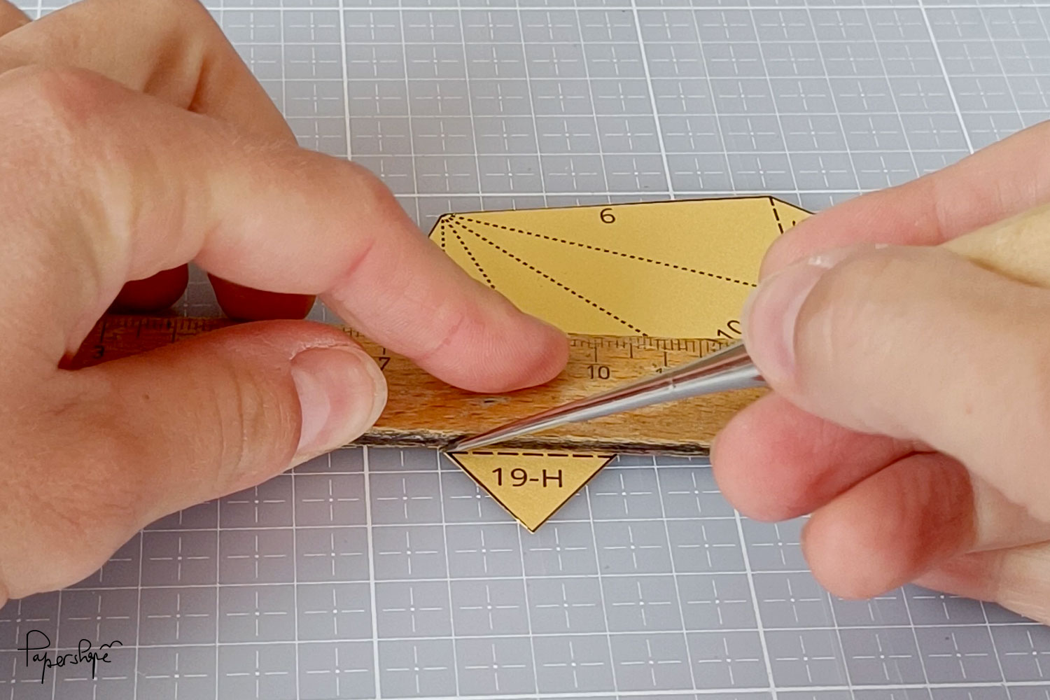 Scoring the fold lines on the paper template for the 12-point Christmas star with a folding tool