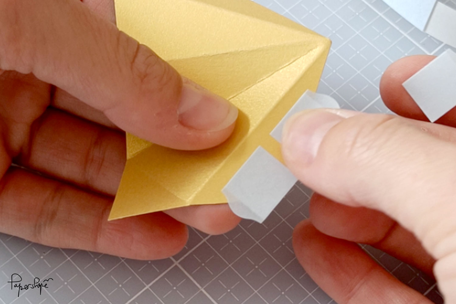 Apply adhesive to the flap of the paper star