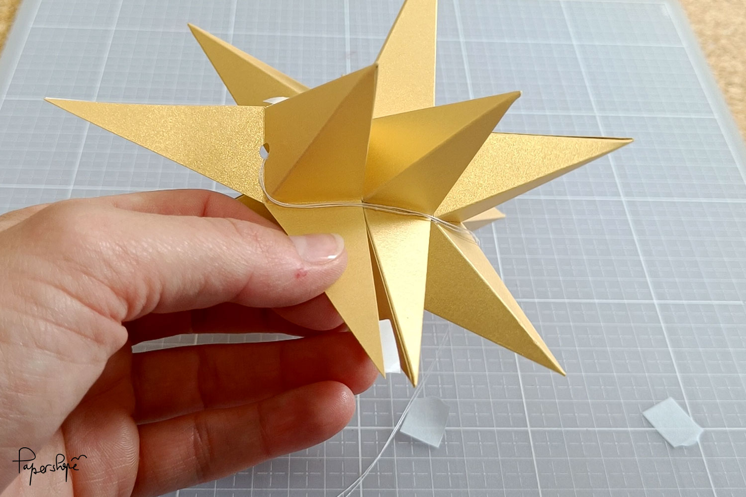 The last prongs of the 12-pointed Christmas star are glued on using a trick: identically long tips make it easier to glue them on cleanly