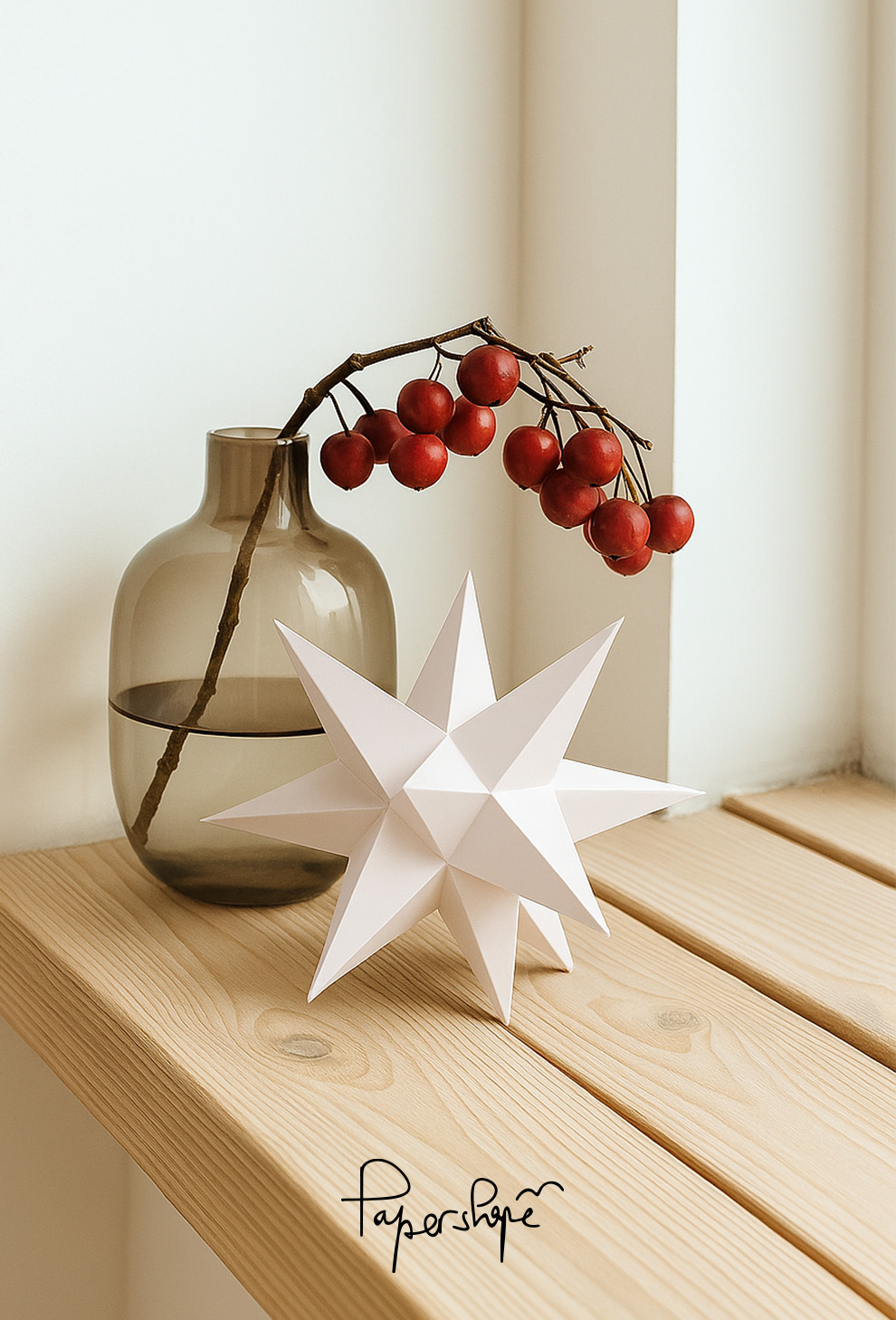 Golden Christmas star made of paper with 12 points is hung on the window with both hands as decoration