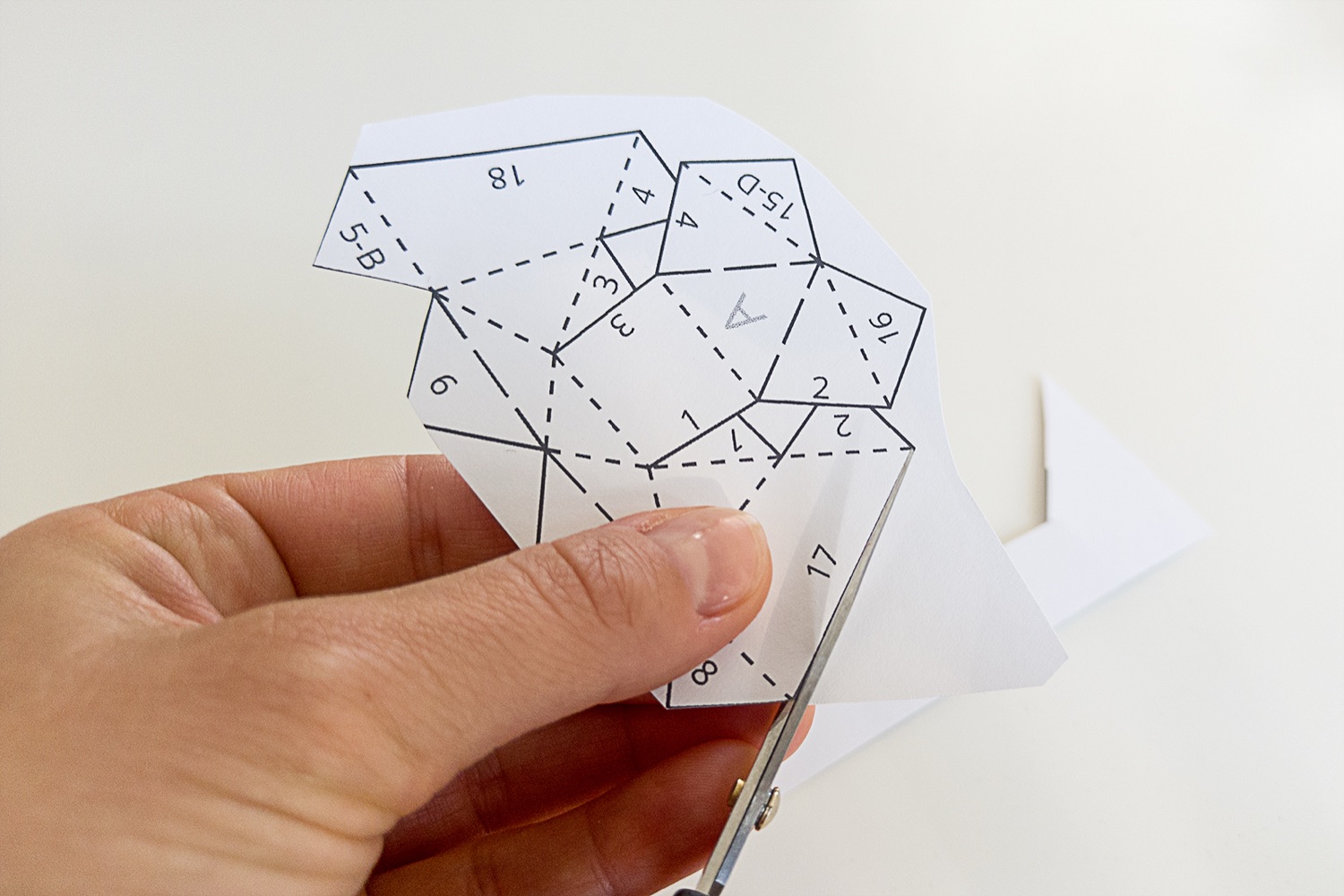 Cutting out the Westie papercraft template with scissors