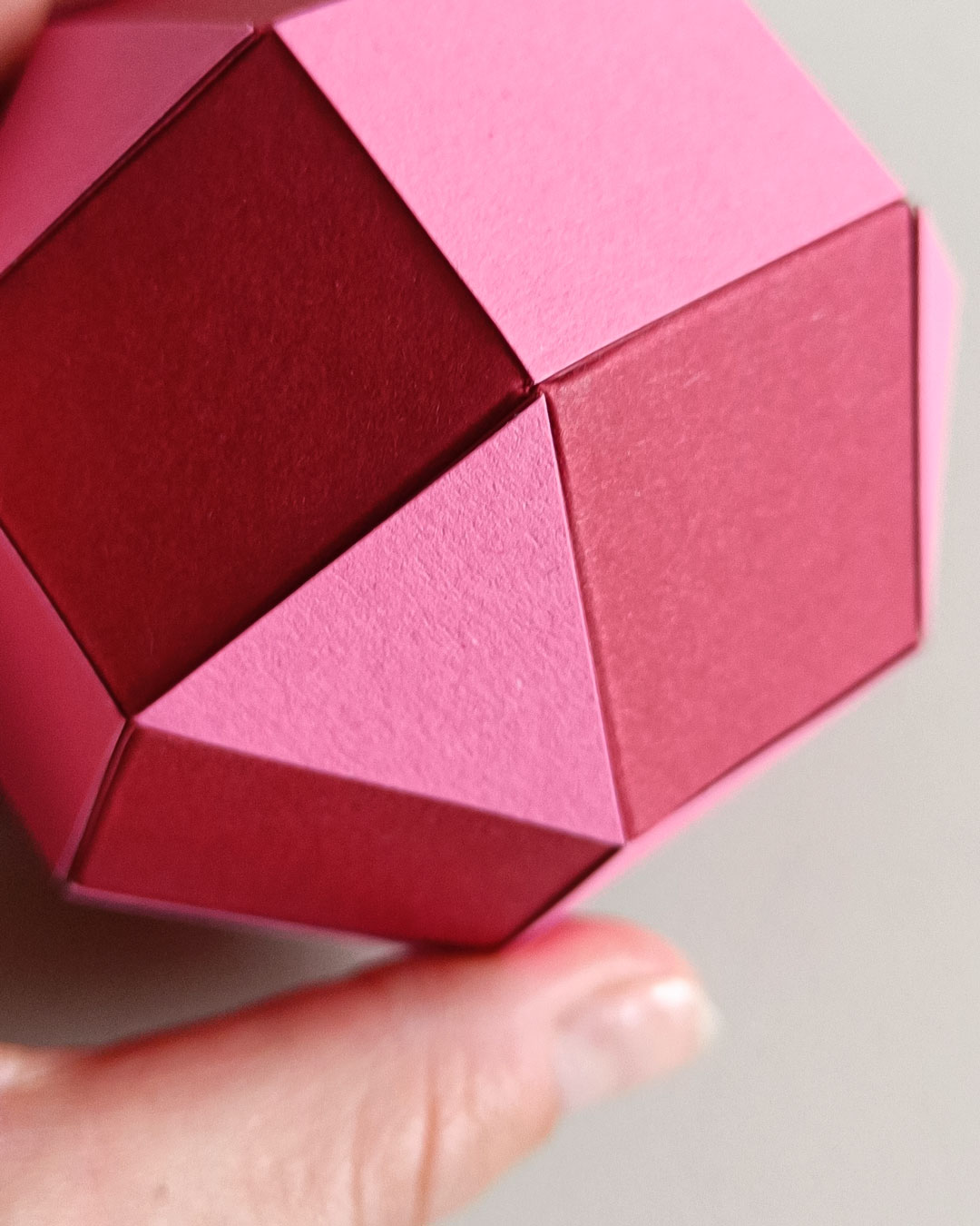 Close-up of a red geometric paper pendant - detailed DIY craftsmanship.