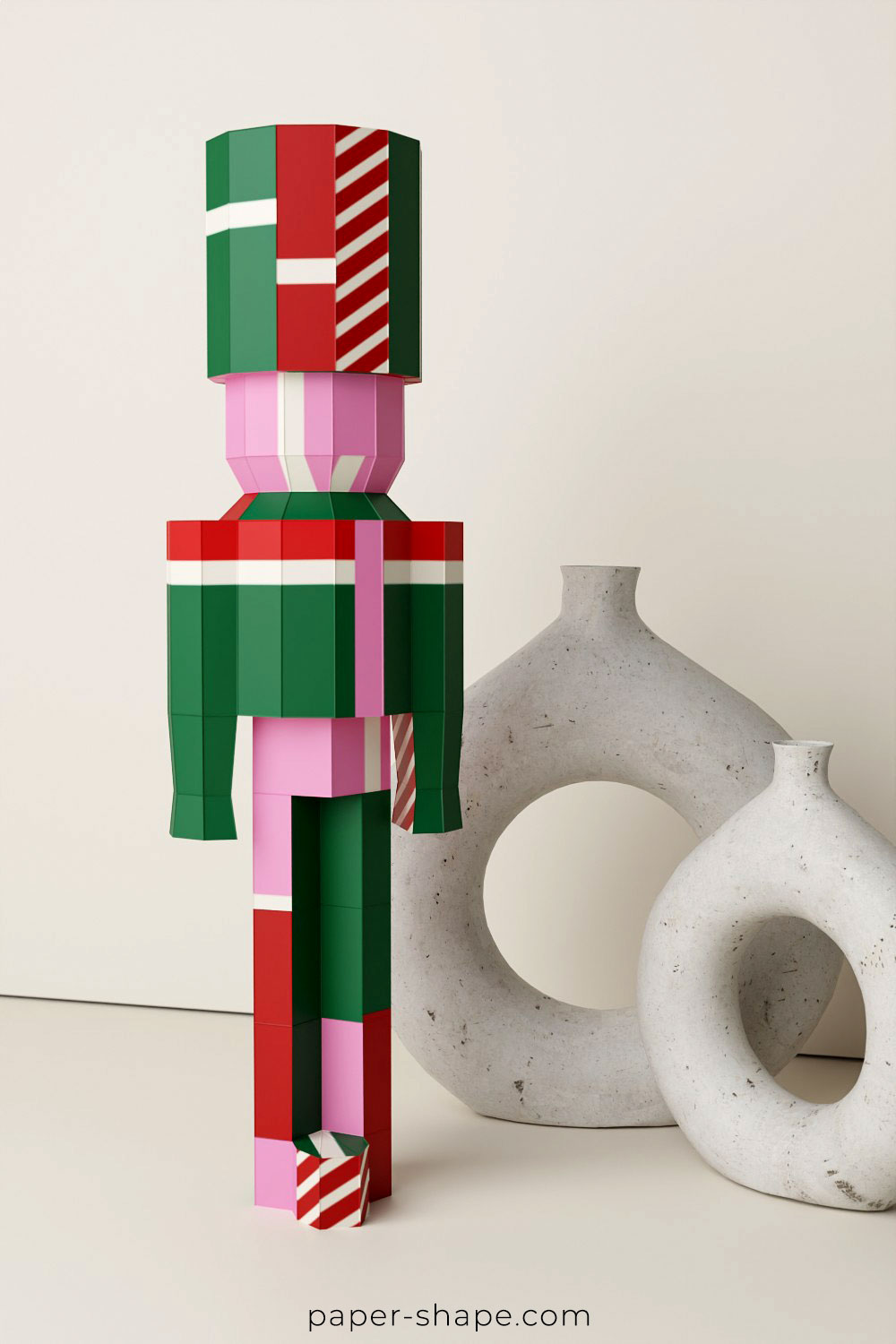 Papercraft nutcracker in red, light purple, royal blue and yellow on a white shelf board