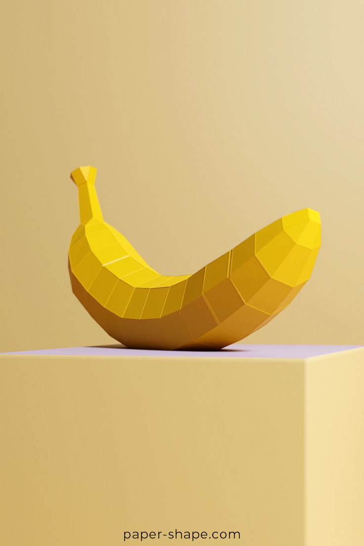 Selbst gebastelte 3D Banane aus Papier in gelb auf einem Podest 