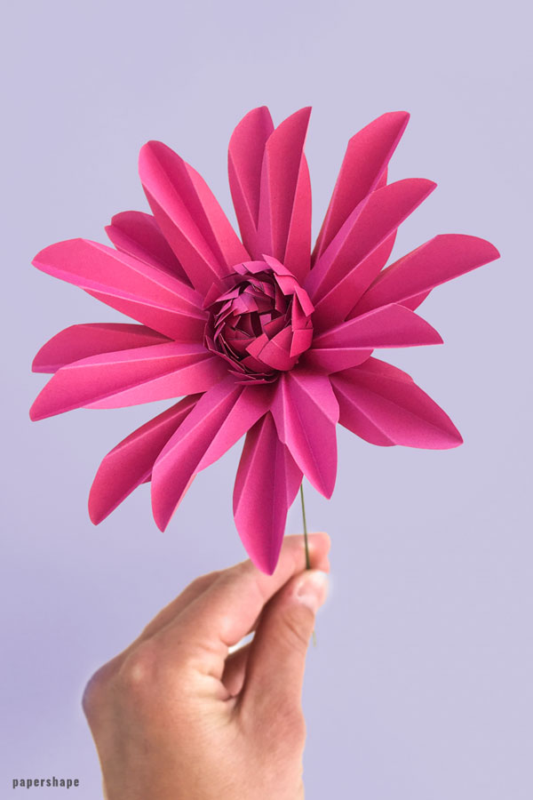 A papercrafted gerbera daisy on a purple background