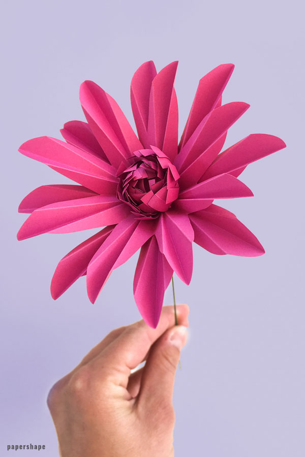 Selbst gebastelte Gerbera aus Papier auf lila Hintergrund